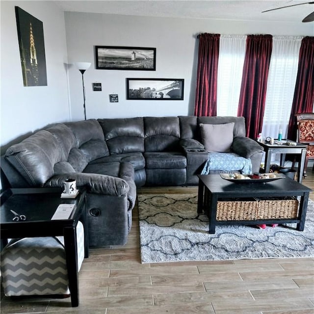 living area with ceiling fan and wood tiled floor