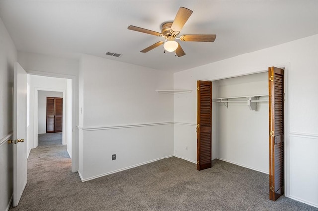 unfurnished bedroom with ceiling fan, a closet, and dark carpet