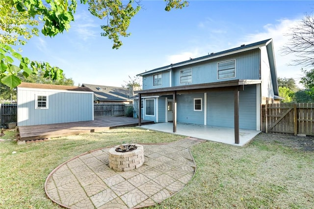 back of property with a patio area, a yard, an outdoor fire pit, and a shed