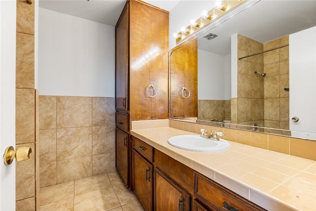 bathroom with tile patterned floors, vanity, and tile walls