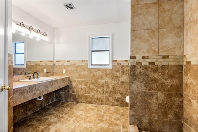 bathroom with sink and tile walls