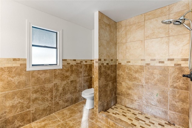 bathroom featuring a tile shower, toilet, and tile walls