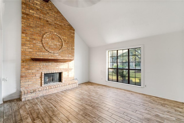 unfurnished living room with a fireplace, high vaulted ceiling, and light hardwood / wood-style flooring