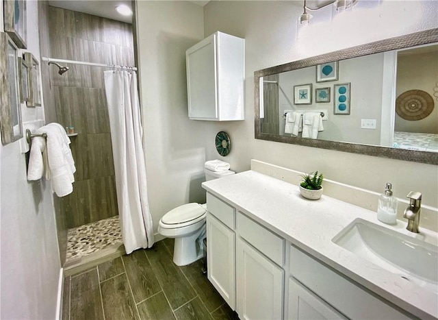 bathroom with toilet, vanity, and a shower with shower curtain