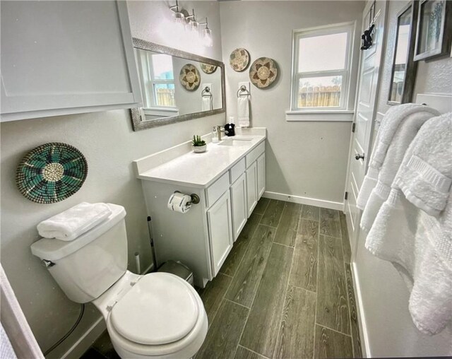 bathroom with vanity, hardwood / wood-style flooring, toilet, and a healthy amount of sunlight