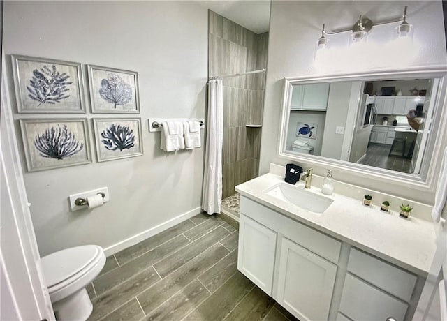 bathroom with wood-type flooring, vanity, toilet, and walk in shower