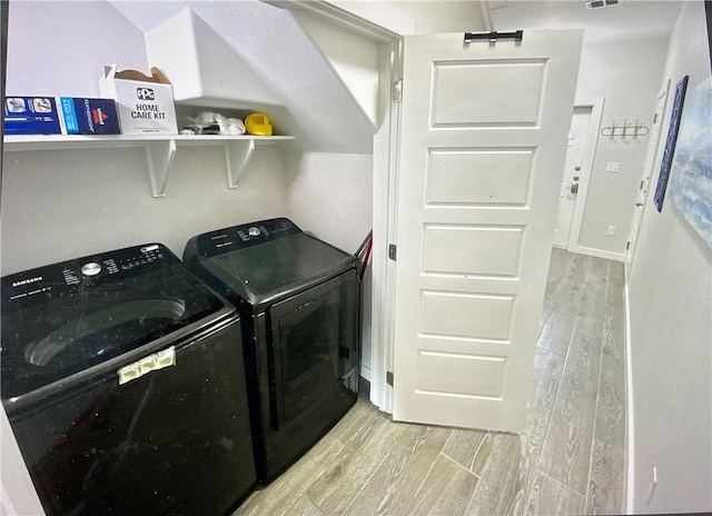 laundry area featuring light wood-type flooring and separate washer and dryer