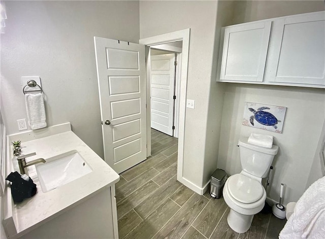 bathroom featuring hardwood / wood-style floors, vanity, and toilet