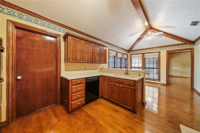 5305 Hunt Cir, Corpus Christi, TX 78413 - kitchen with black dishwasher, dark wood finished floors, a peninsula, light countertops, and brown cabinetry