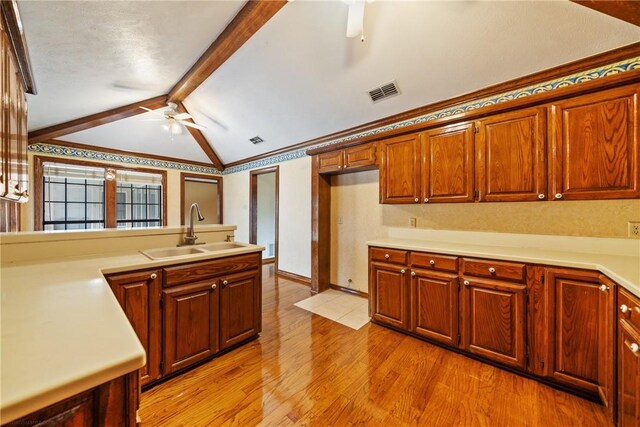 5305 Hunt Cir, Corpus Christi, TX 78413 - kitchen with a ceiling fan, light wood finished floors, light countertops, and brown cabinets