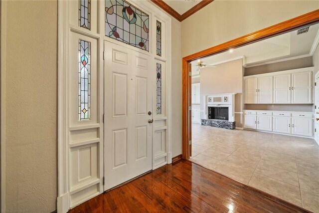 5305 Hunt Cir, Corpus Christi, TX 78413 - foyer entrance with ornamental molding, a fireplace with raised hearth, a ceiling fan, and dark wood finished floors