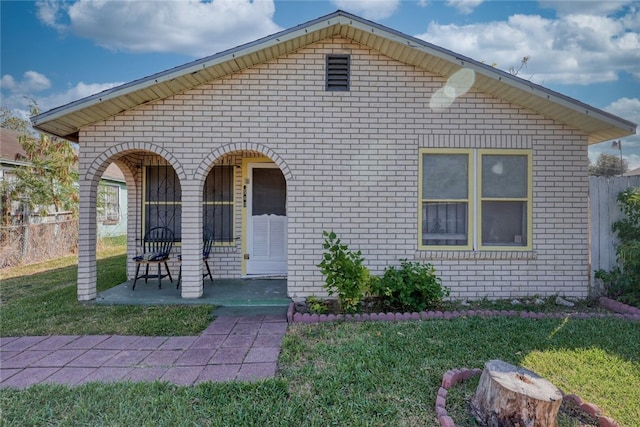 view of front of property with covered porch and a front lawn