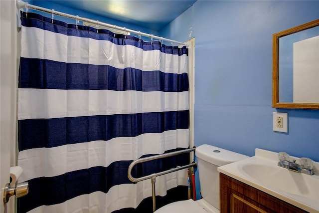 bathroom with walk in shower, vanity, and toilet