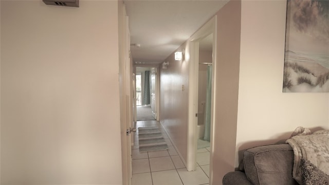 hall with light tile patterned floors