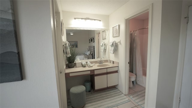 bathroom with vanity, a textured ceiling, and toilet