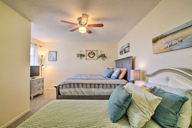 carpeted bedroom featuring ceiling fan and a textured ceiling