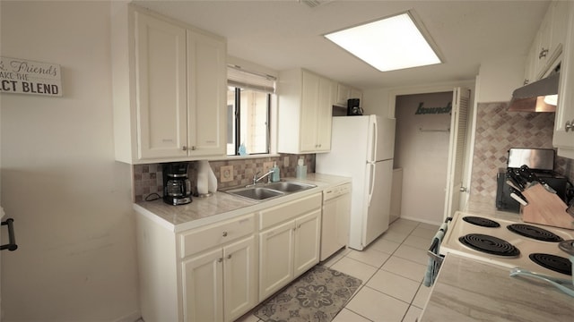 kitchen with light tile patterned flooring, sink, white cabinetry, tasteful backsplash, and white appliances