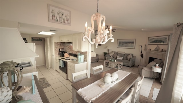 dining room featuring lofted ceiling, light tile patterned floors, and an inviting chandelier