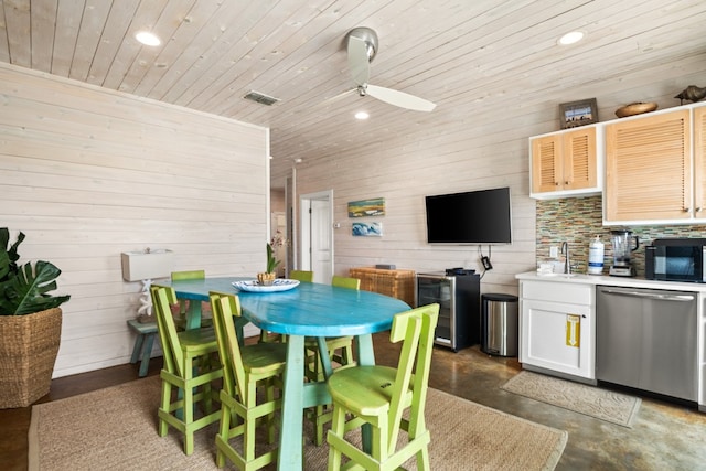 dining room featuring wood walls, ceiling fan, and wood ceiling