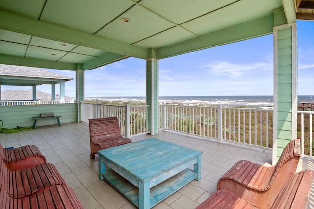 view of patio / terrace with a beach view and a water view