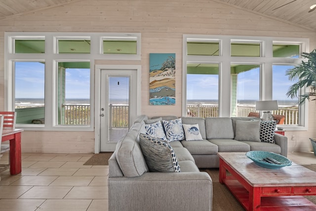 living room with a wealth of natural light, a water view, and lofted ceiling