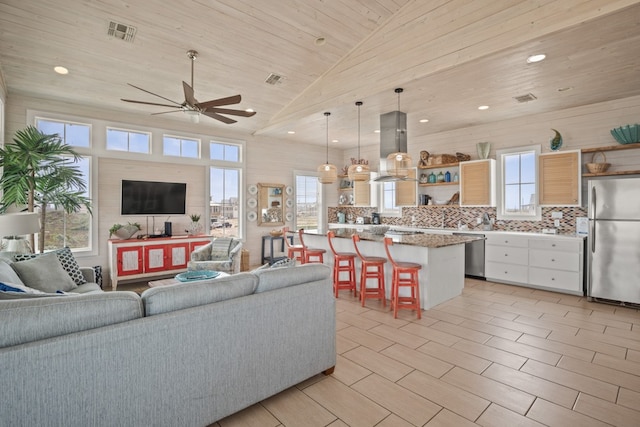 living room with lofted ceiling, a wealth of natural light, wooden ceiling, and ceiling fan