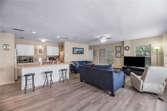 245 Griffith Dr, Rockport, TX 78382 - living room with a ceiling fan, a textured ceiling, visible vents, recessed lighting, and light wood-style flooring