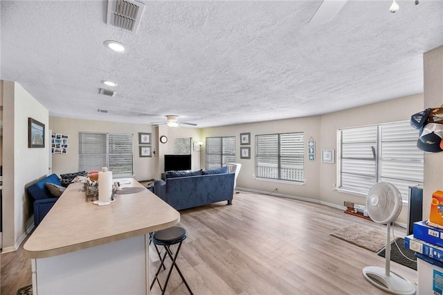 245 Griffith Dr, Rockport, TX 78382 - living area featuring a textured ceiling, visible vents, ceiling fan, and light wood-type flooring