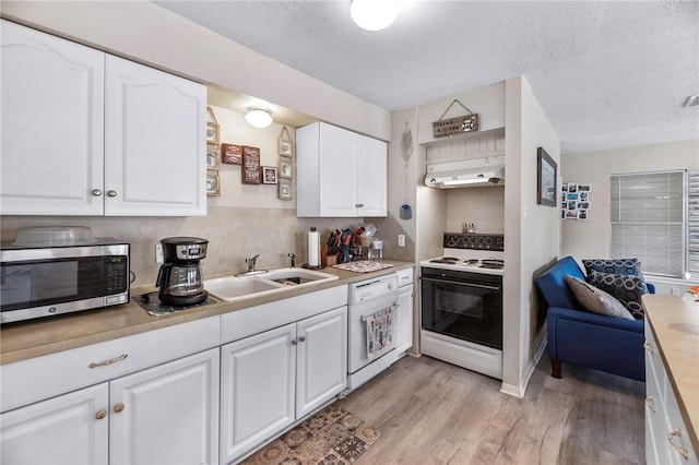 245 Griffith Dr, Rockport, TX 78382 - kitchen featuring white appliances, light wood-style floors, light countertops, white cabinetry, and a sink