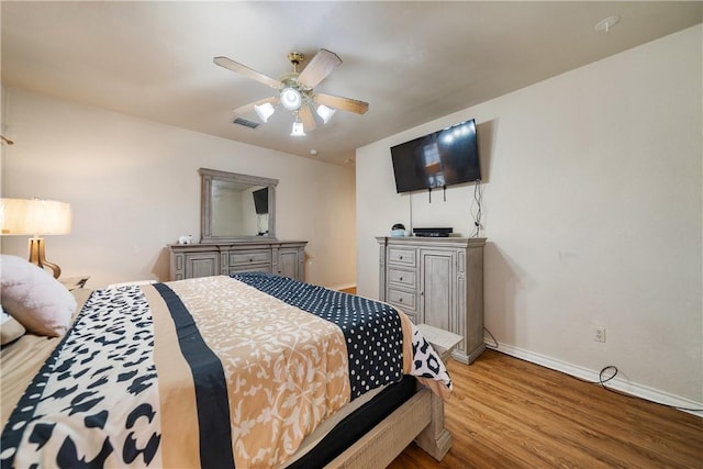 bedroom featuring ceiling fan, baseboards, wood finished floors, and visible vents