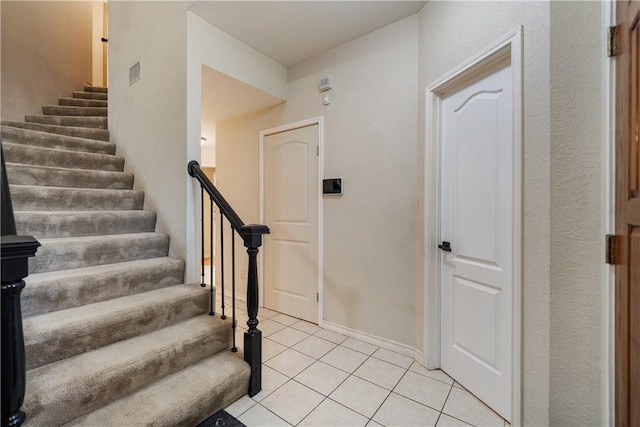 staircase with baseboards and tile patterned flooring