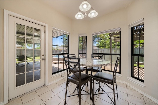 dining space featuring baseboards, an inviting chandelier, and light tile patterned floors