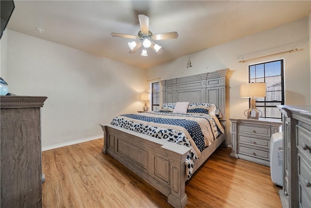 bedroom featuring light wood-type flooring, a ceiling fan, and baseboards