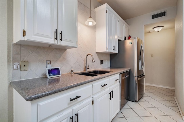 kitchen featuring stainless steel dishwasher, tasteful backsplash, a sink, and visible vents