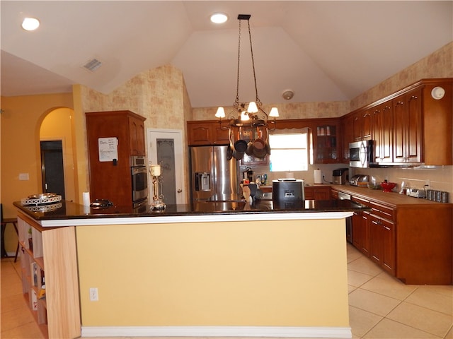 kitchen featuring stainless steel appliances, lofted ceiling, a chandelier, and a center island