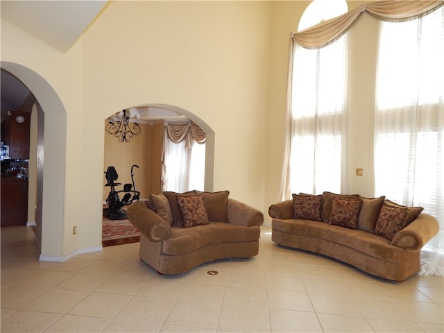 living room featuring a healthy amount of sunlight, light tile patterned floors, and an inviting chandelier