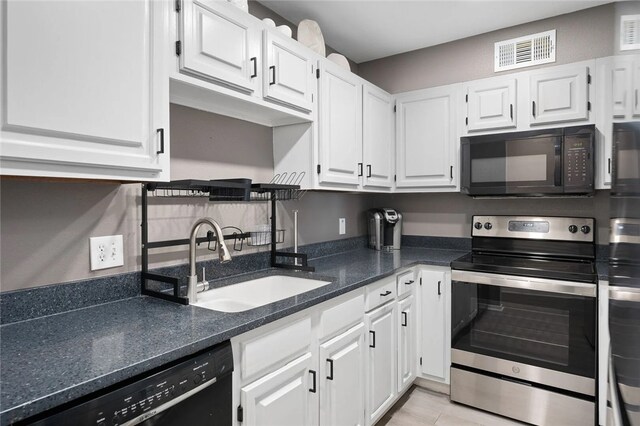 5973 State Highway 361 Unit 123, Port Aransas, TX 78373 - kitchen with black appliances, white cabinets, and dark stone counters