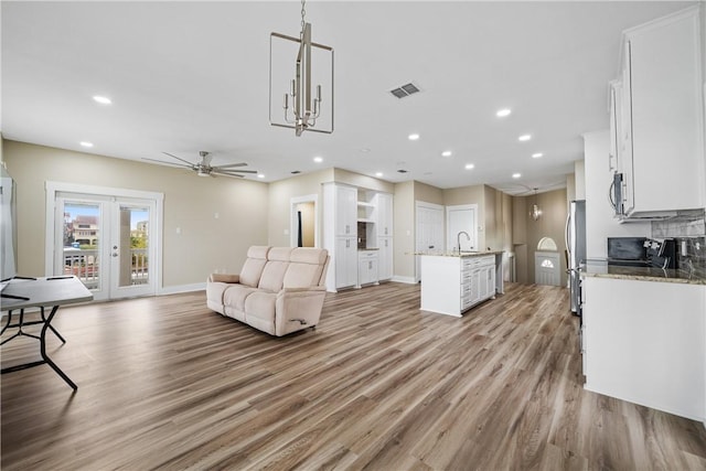 738 Crown Hbr, Corpus Christi, TX 78402 - living room featuring light wood-type flooring, visible vents, recessed lighting, and ceiling fan with notable chandelier