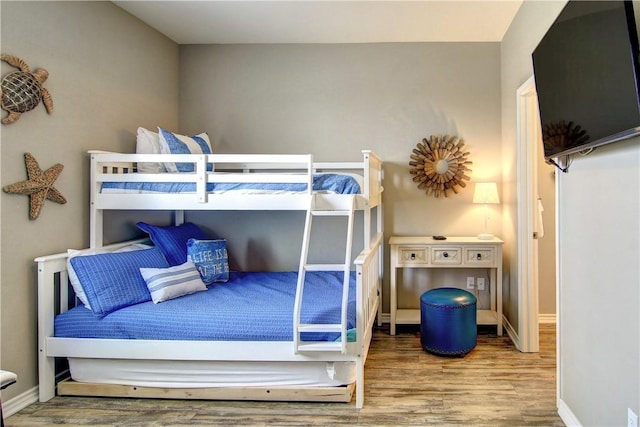 bedroom with baseboards and wood finished floors