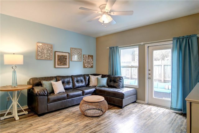living room with baseboards, ceiling fan, and wood finished floors