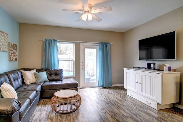 living area featuring baseboards, ceiling fan, and wood finished floors