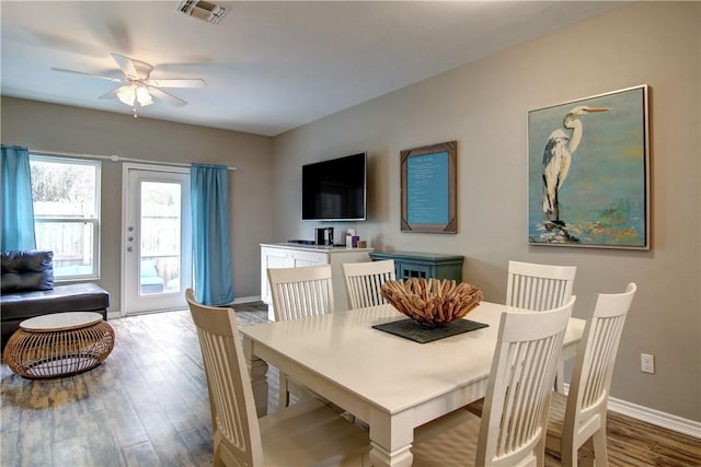 dining space featuring baseboards, ceiling fan, visible vents, and wood finished floors