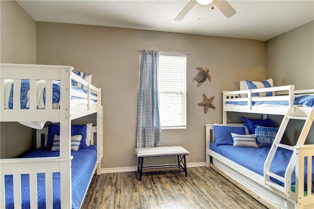 bedroom featuring a ceiling fan, baseboards, and wood finished floors