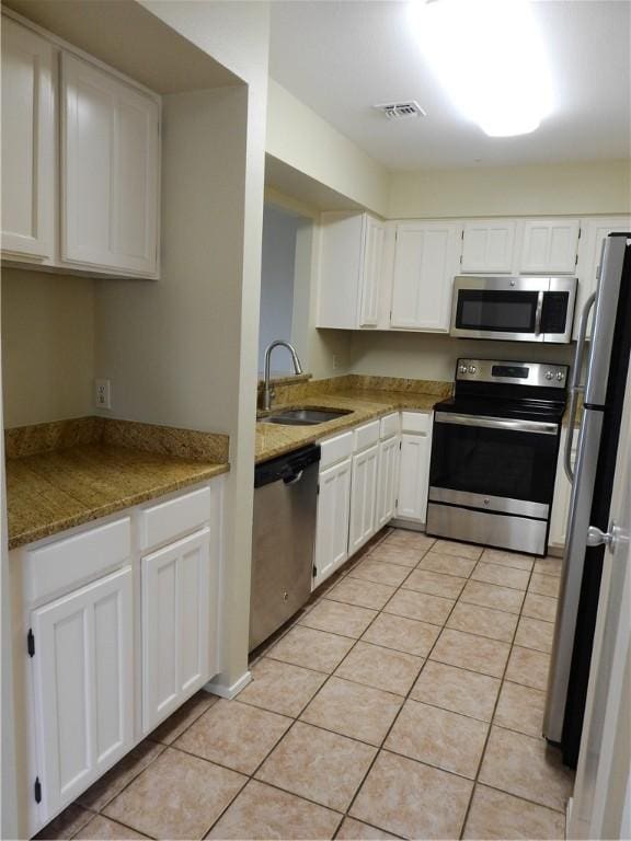 4401 River Valley Dr, Corpus Christi, TX 78410 - kitchen with stainless steel appliances, white cabinetry, light tile patterned flooring, and light stone counters
