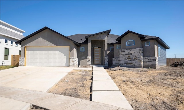 view of front of house with a garage, stone siding, concrete driveway, and stucco siding