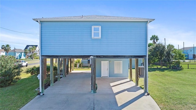 exterior space with a yard, cooling unit, and a carport