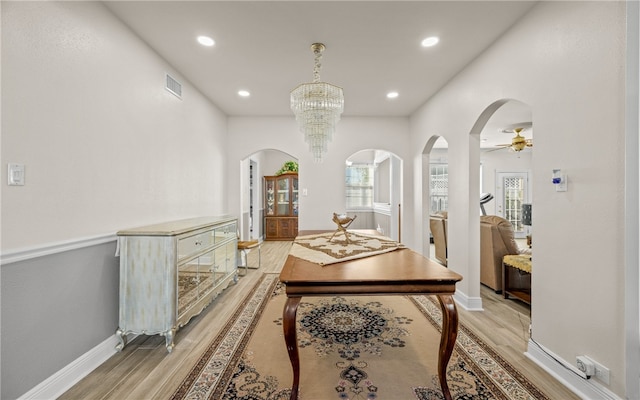 corridor with a chandelier and light hardwood / wood-style floors