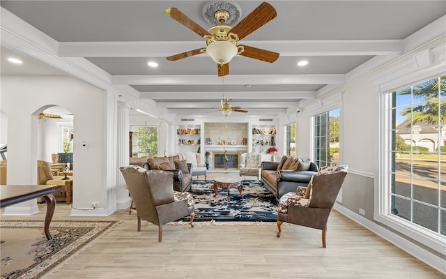 sunroom / solarium featuring ceiling fan, plenty of natural light, and beamed ceiling