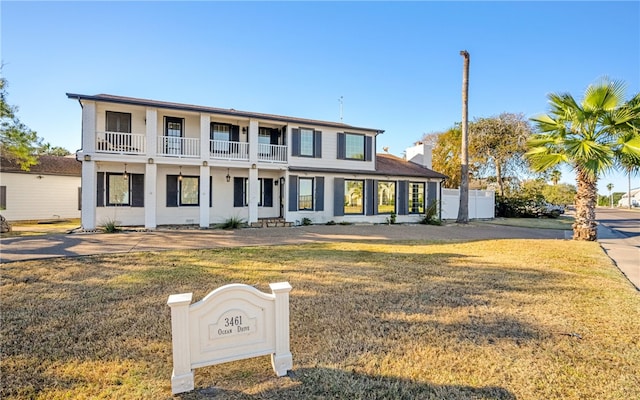 view of front facade featuring a balcony and a front yard