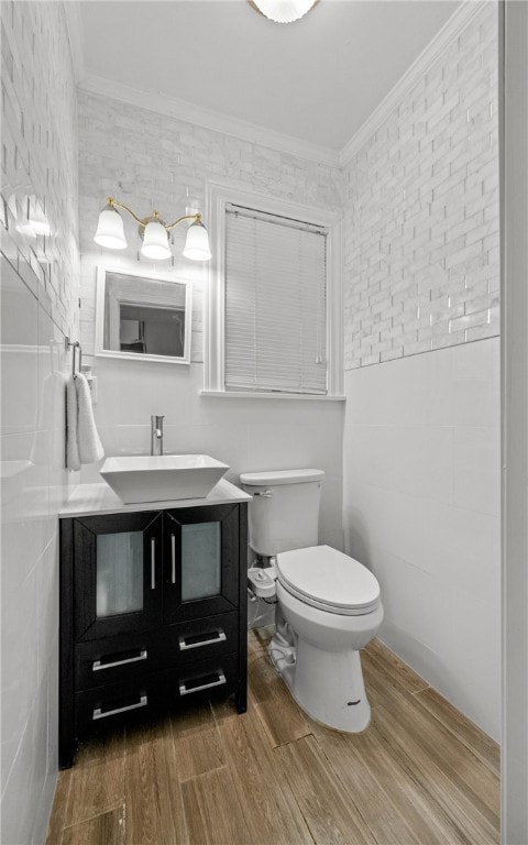 bathroom with wood-type flooring, crown molding, and tile walls